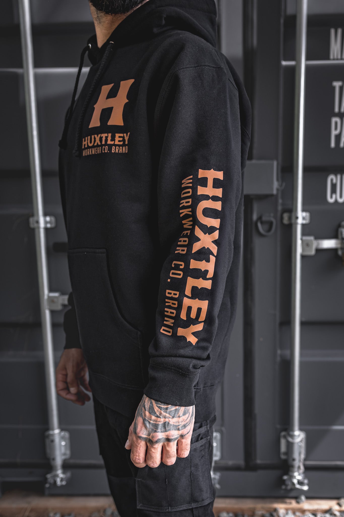 
                  
                    Side angle of the Full Print Hoodie featuring Huxtley branding on the chest and down the sleeve. Built for rugged workdays, styled for pride.
                  
                