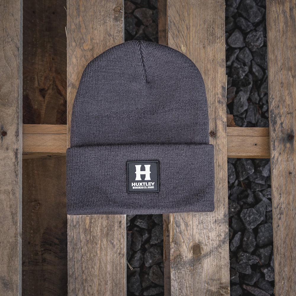 The Huxtley Classic Beanie in Gunmetal brings tough warmth to any cold shift. Built from thick ribbed knit with a bold rubber patch, it’s the go-to lid for tradesmen who don’t clock out when the weather hits.