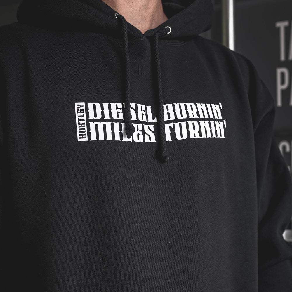 
                  
                    Tight shot of the “Diesel Burnin’ Miles Turnin’” print on a black Huxtley hoodie. Sharp lettering, tough fleece, and built for life on the road.
                  
                
