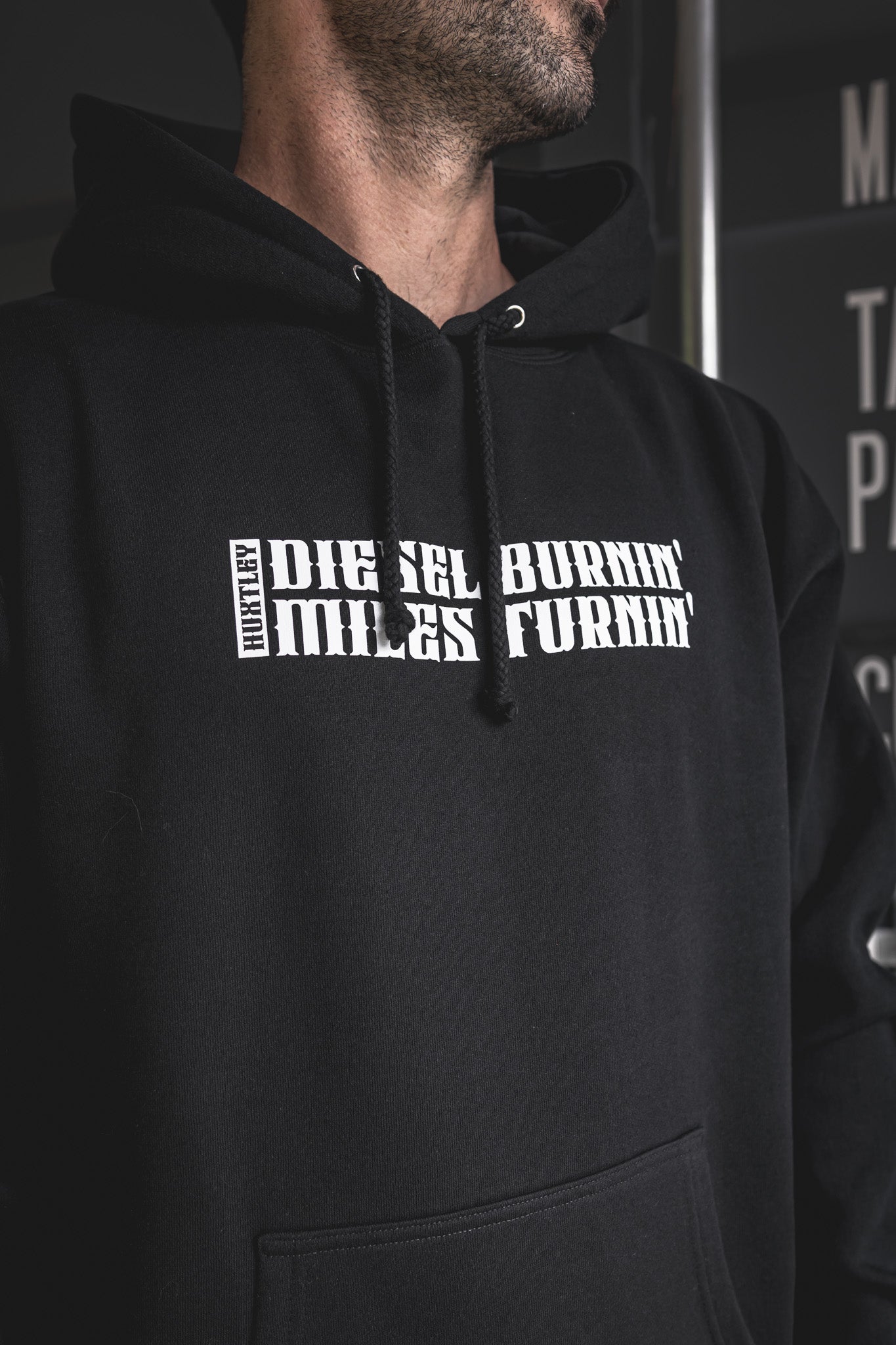 
                  
                    Tight shot of the “Diesel Burnin’ Miles Turnin’” print on a black Huxtley hoodie. Sharp lettering, tough fleece, and built for life on the road.
                  
                