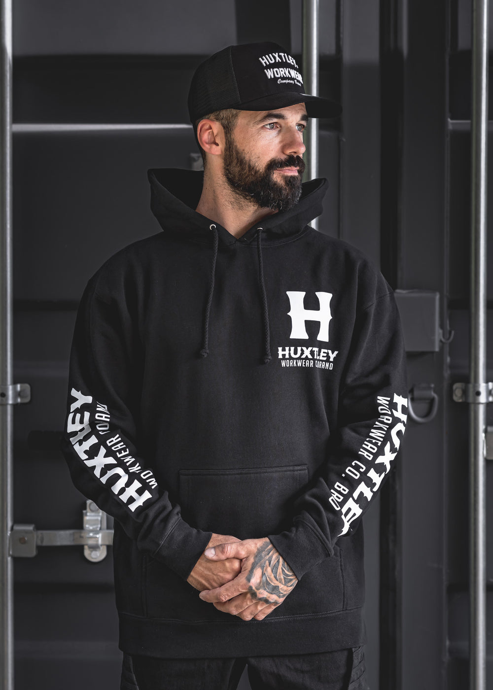 The Huxtley Full Print Hoodie with crisp white logos on chest and sleeves. Clean, bold, and built for work—this hoodie reps the brand loud and clear.