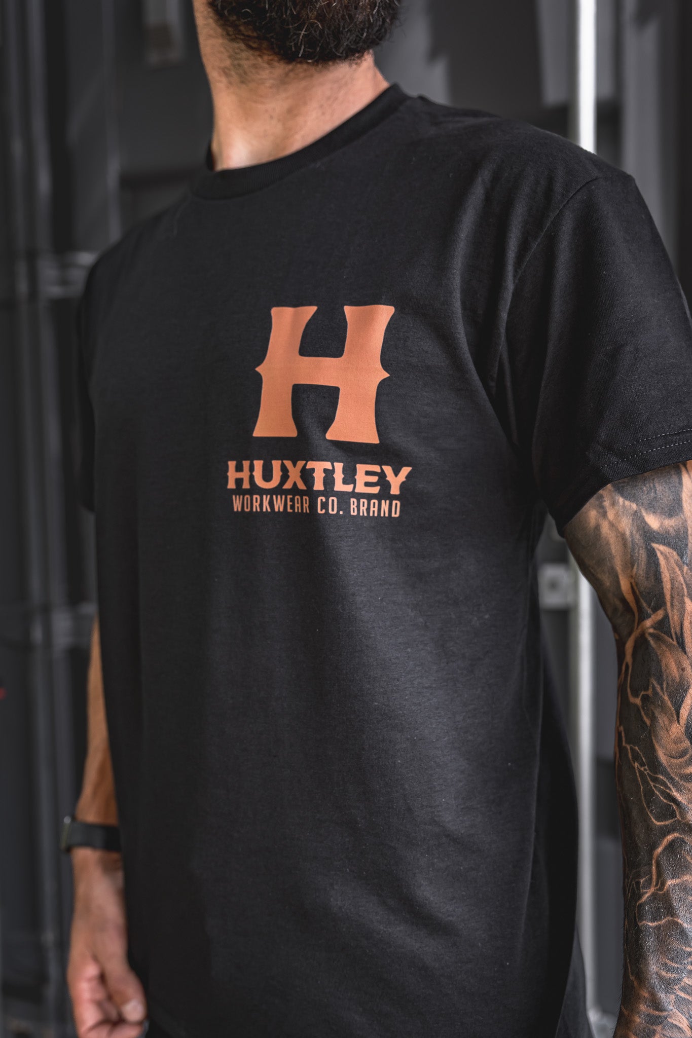 
                  
                    Close-up of the whiskey-colored Huxtley logo on the chest of the Full Print tee. Clean lines, bold print, and premium black cotton.
                  
                