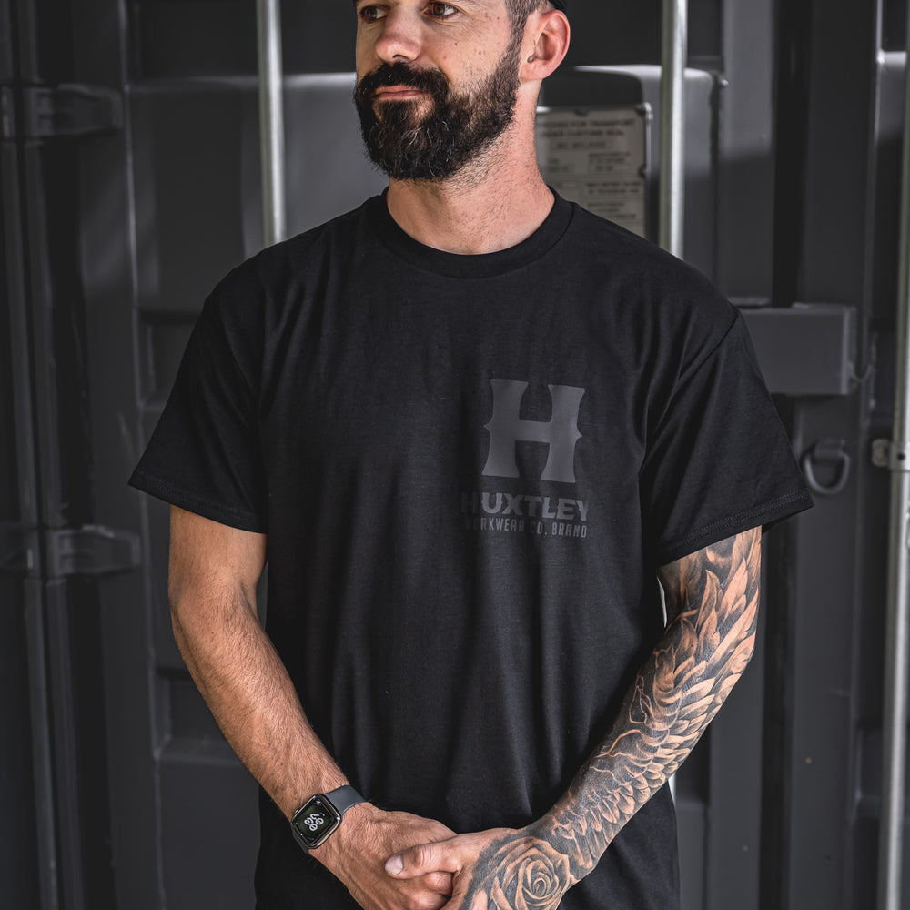 
                  
                    Front view of the Huxtley Full Print T-shirt with blackout logo. Clean, stealthy, and made to last — perfect for the jobsite or weekend runaround.
                  
                