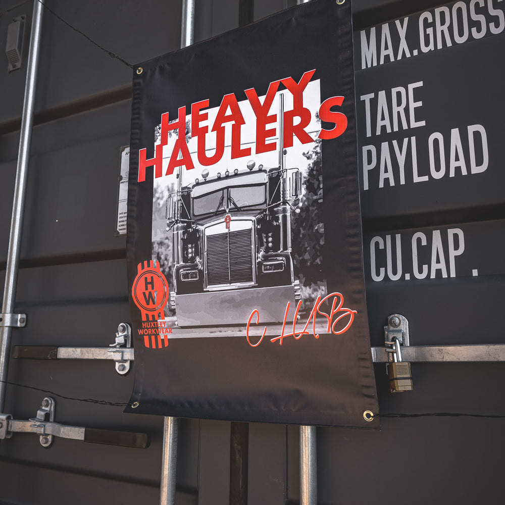 Dominate the yard with the exclusive “Heavy Haulers” banner by Huxtley Workwear. A club-only flag for long-haul beasts and gearheads who live for the road.