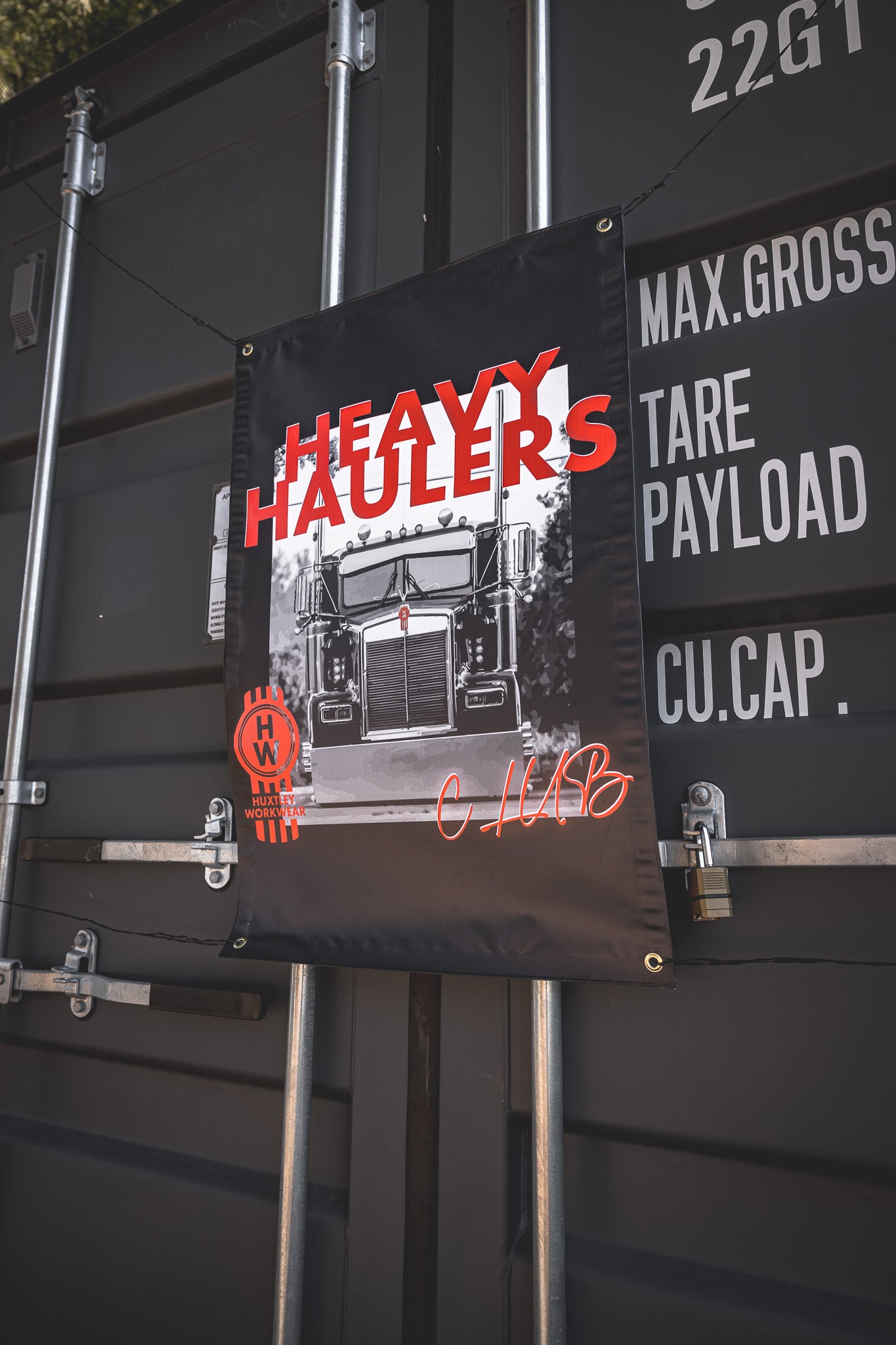 Dominate the yard with the exclusive “Heavy Haulers” banner by Huxtley Workwear. A club-only flag for long-haul beasts and gearheads who live for the road.
