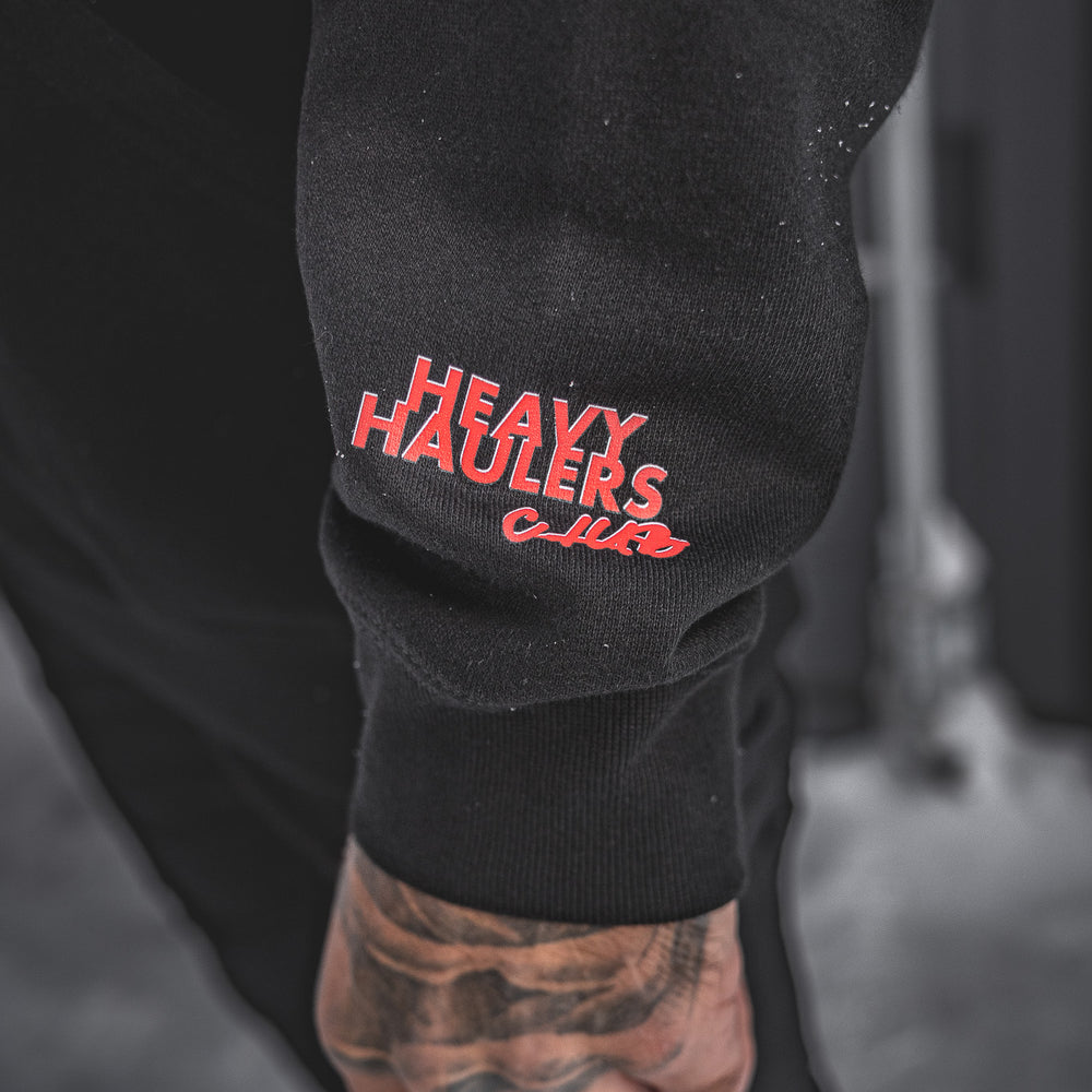 
                  
                    Join the crew with the Huxtley Heavy Haulers Club Hoodie. Built from heavyweight black fleece, it features bold chest and sleeve prints, plus a massive truck graphic on the back. This one's for the road dogs and rig riders.
                  
                