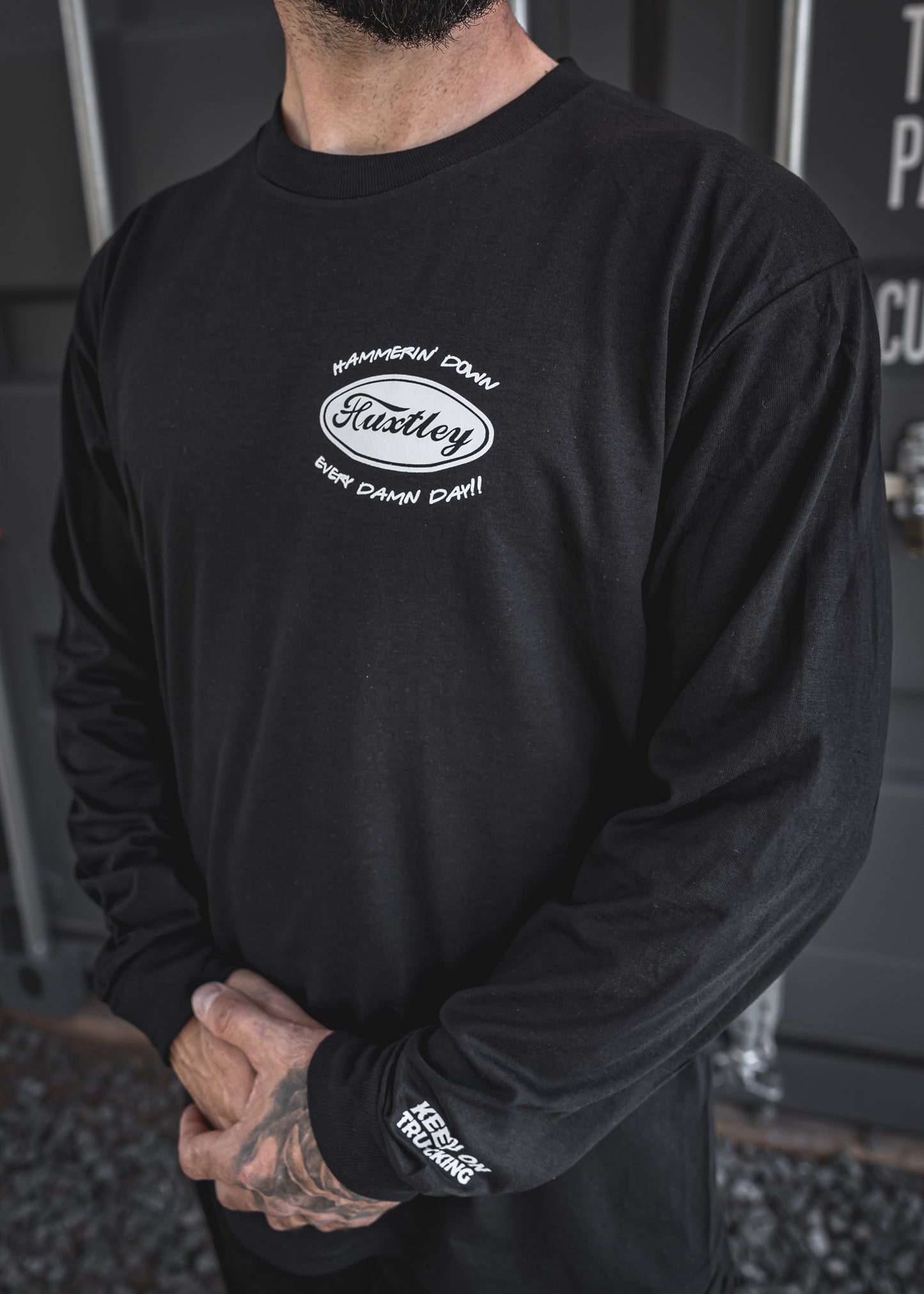 
                  
                    Close-up of the “Hammerin’ Down Every Damn Day!!” chest hit with retro Huxtley oval logo. Sleeve reads “Keep On Trucking” to keep the highway vibes rollin’.
                  
                