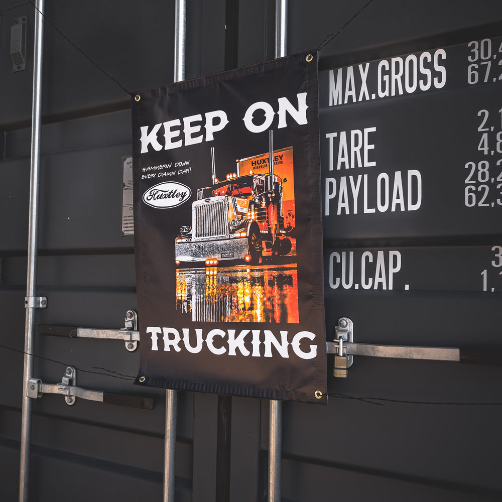 Bring the energy of the open road to your setup with Huxtley’s “Keep On Trucking” banner. Big rig graphics, jobsite grit, and a whole lotta attitude. Hammerin’ down, every damn day.