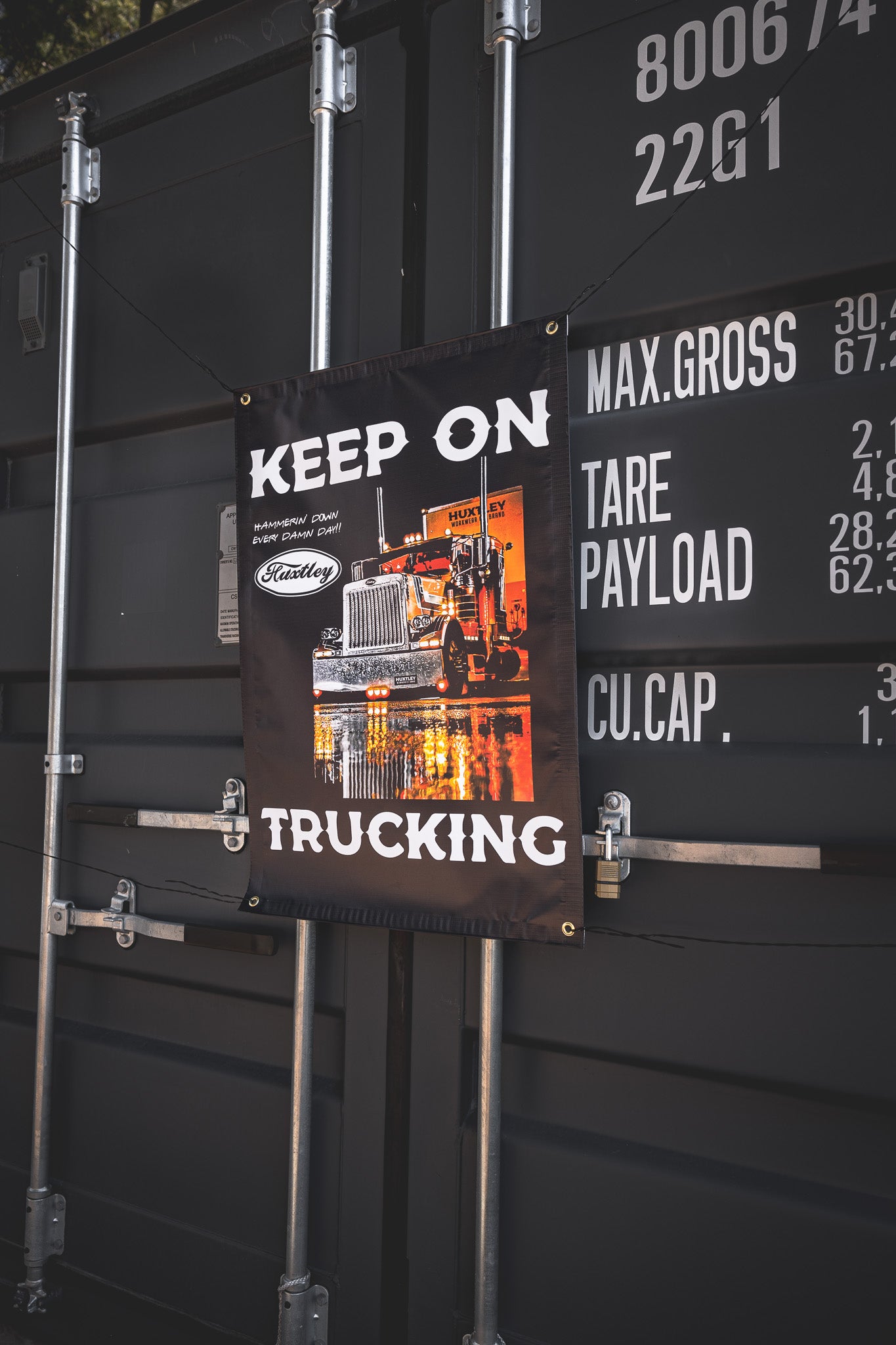 Bring the energy of the open road to your setup with Huxtley’s “Keep On Trucking” banner. Big rig graphics, jobsite grit, and a whole lotta attitude. Hammerin’ down, every damn day.