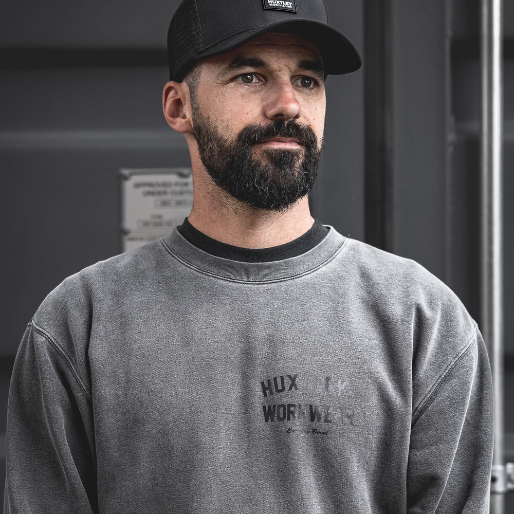 
                  
                    A clean shot of the Huxtley patch logo cap worn on-site, paired with the faded crewneck. Built tough, made to wear daily — on or off the job.
                  
                