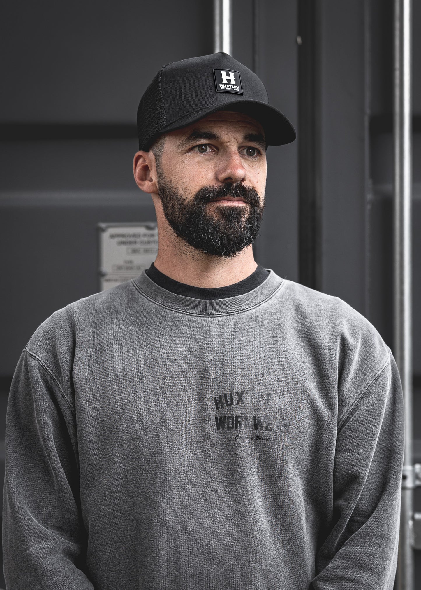 
                  
                    A clean shot of the Huxtley patch logo cap worn on-site, paired with the faded crewneck. Built tough, made to wear daily — on or off the job.
                  
                