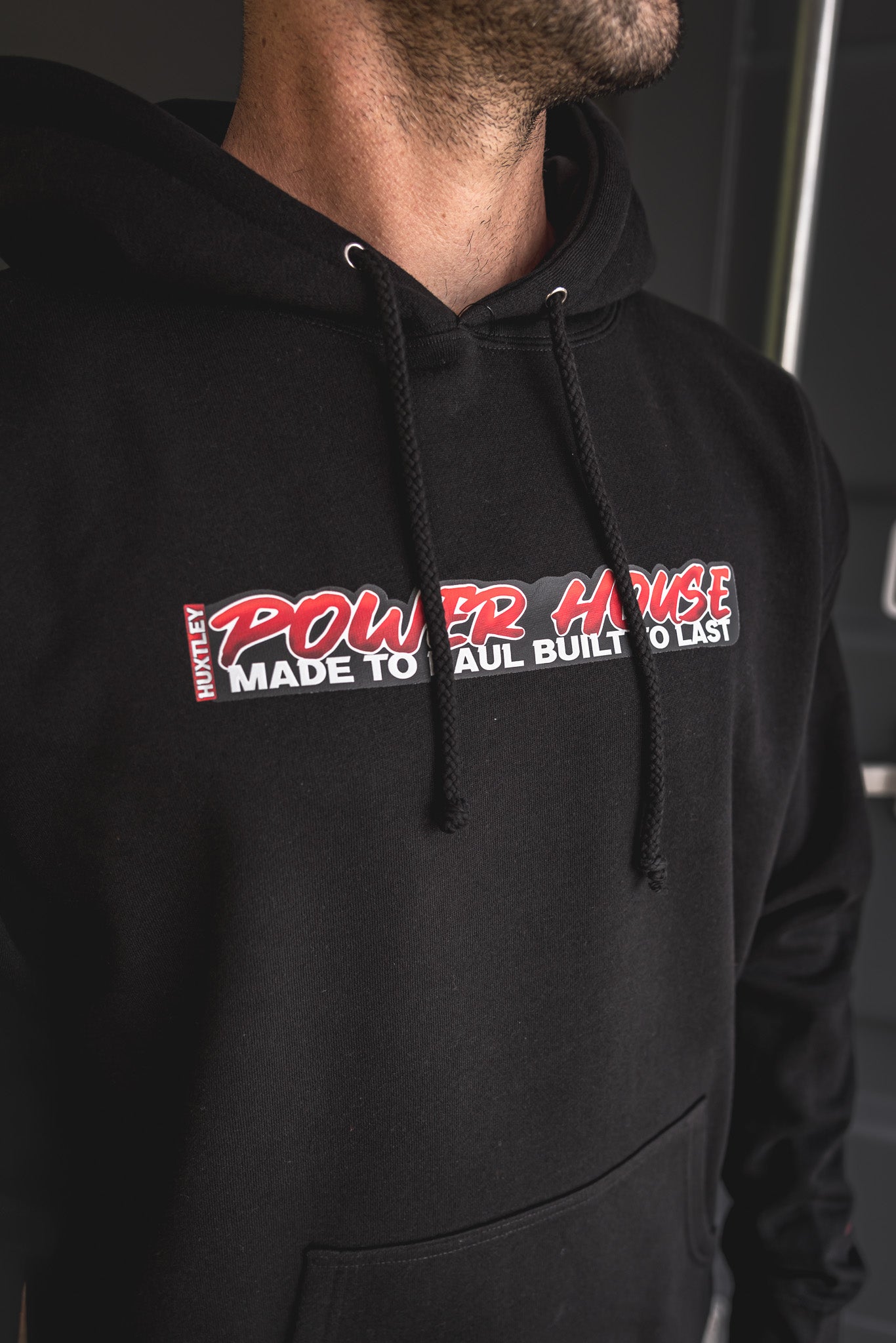 
                  
                    Detailed view of the “POWER HOUSE – Made to Haul, Built to Last” chest graphic on black Huxtley hoodie. Bold print, clean stitching, and built for rugged wear.
                  
                