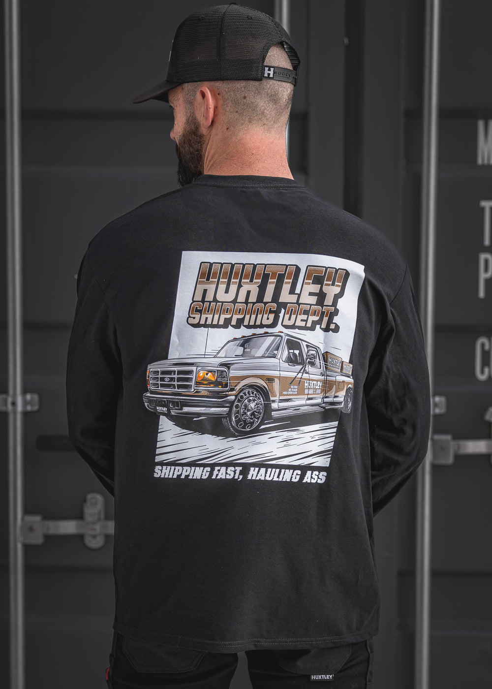 Back view of the black Huxtley Shipping Dept. long sleeve tee featuring a bold graphic of a lifted Ford pickup and the tagline “Shipping Fast, Hauling Ass.” A tribute to the hustle, printed on heavy cotton. Perfect for the shop or the streets.