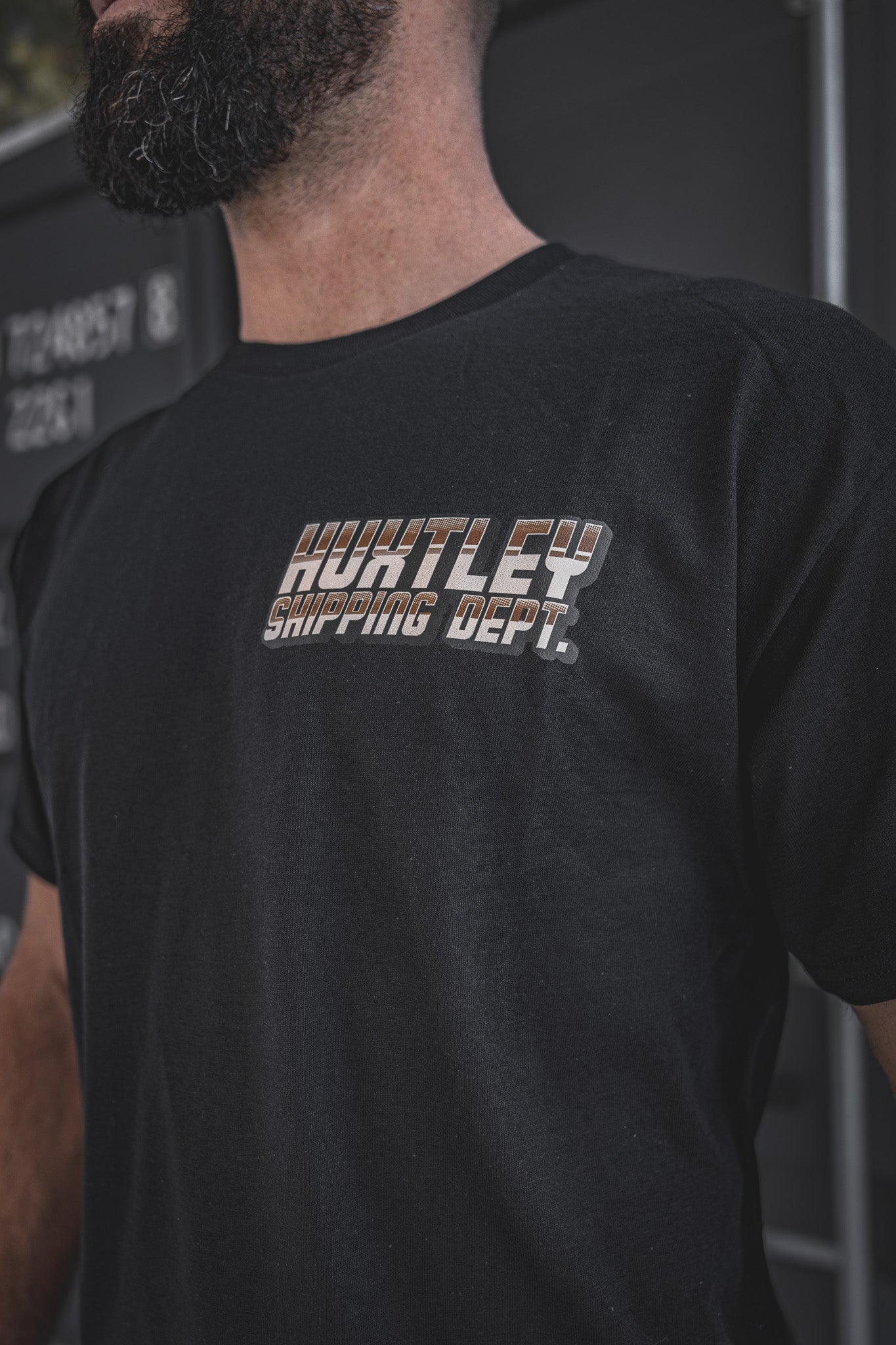 
                  
                    Detailed close-up of the Huxtley Shipping Dept. logo on the chest of the black short sleeve tee. Built for the yard, styled for the street — clean look with vintage truck-shop energy.
                  
                