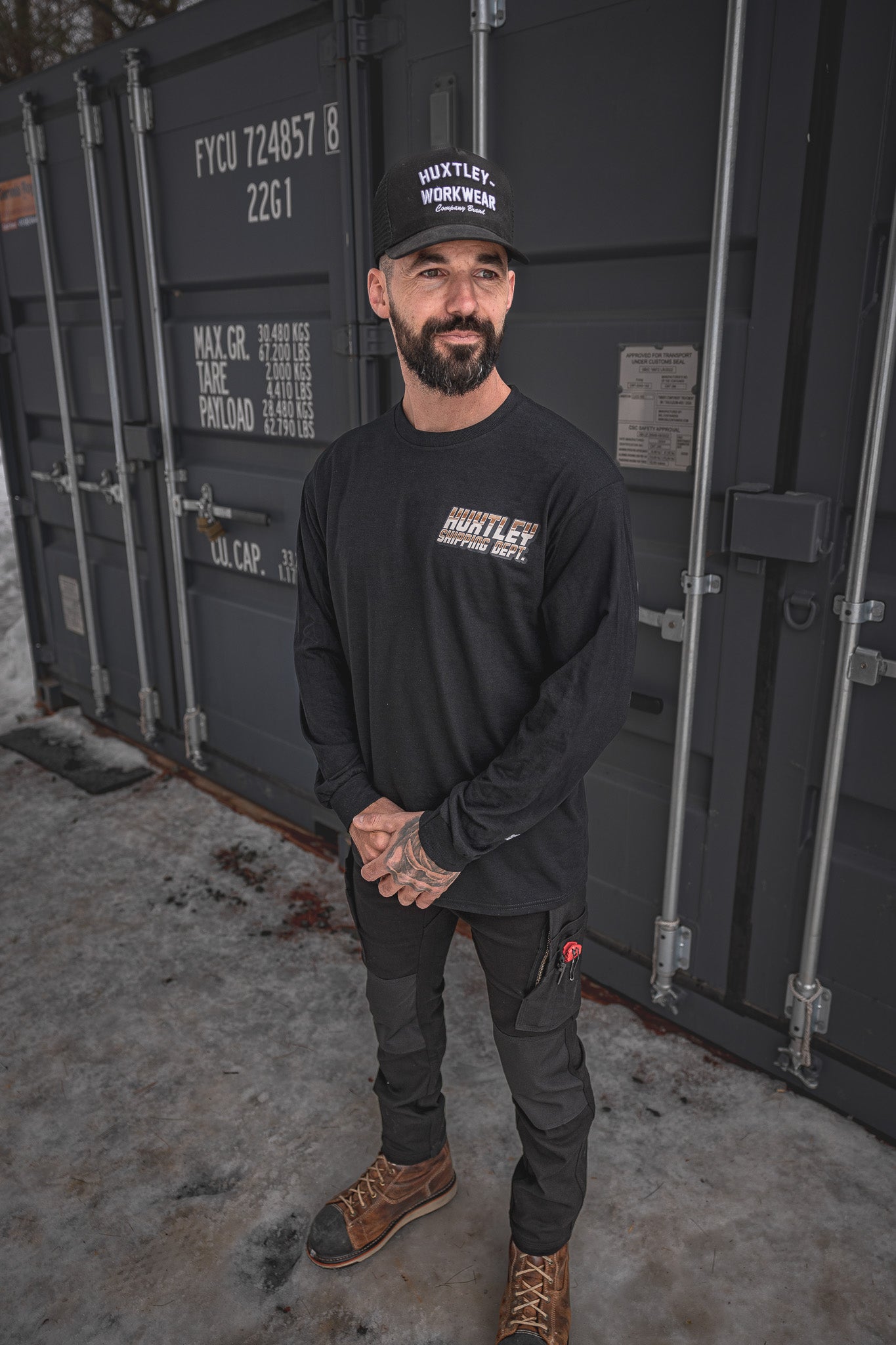 
                  
                    Model wearing the Huxtley Shipping Dept. long sleeve tee in black paired with Huxtley FX-1 Slim Pro Pants Blackout. Rugged workwear with a clean silhouette—made for hard shifts and cold yards.
                  
                