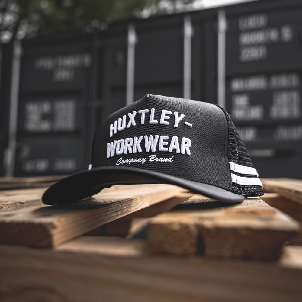 
                  
                    The Throwback cap from Huxtley brings a modern edge to old-school workwear. Featuring bold arched embroidery and heritage-style striping, it’s built for the jobsite and beyond.
                  
                
