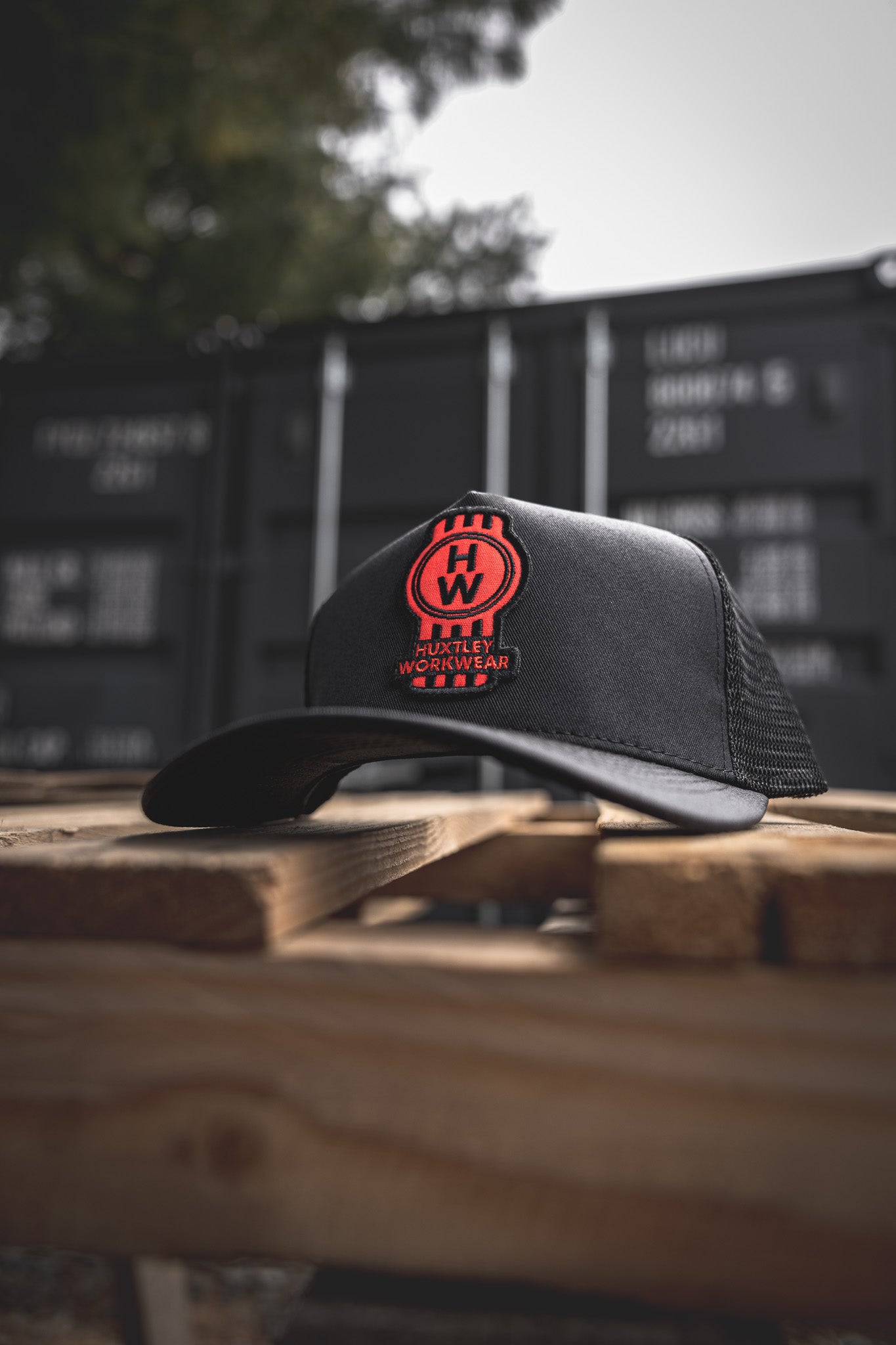 
                  
                    Front and center: the red HW badge on our classic black trucker hat. Tough mesh, curved brim, and built for the jobsite or the weekend run.
                  
                