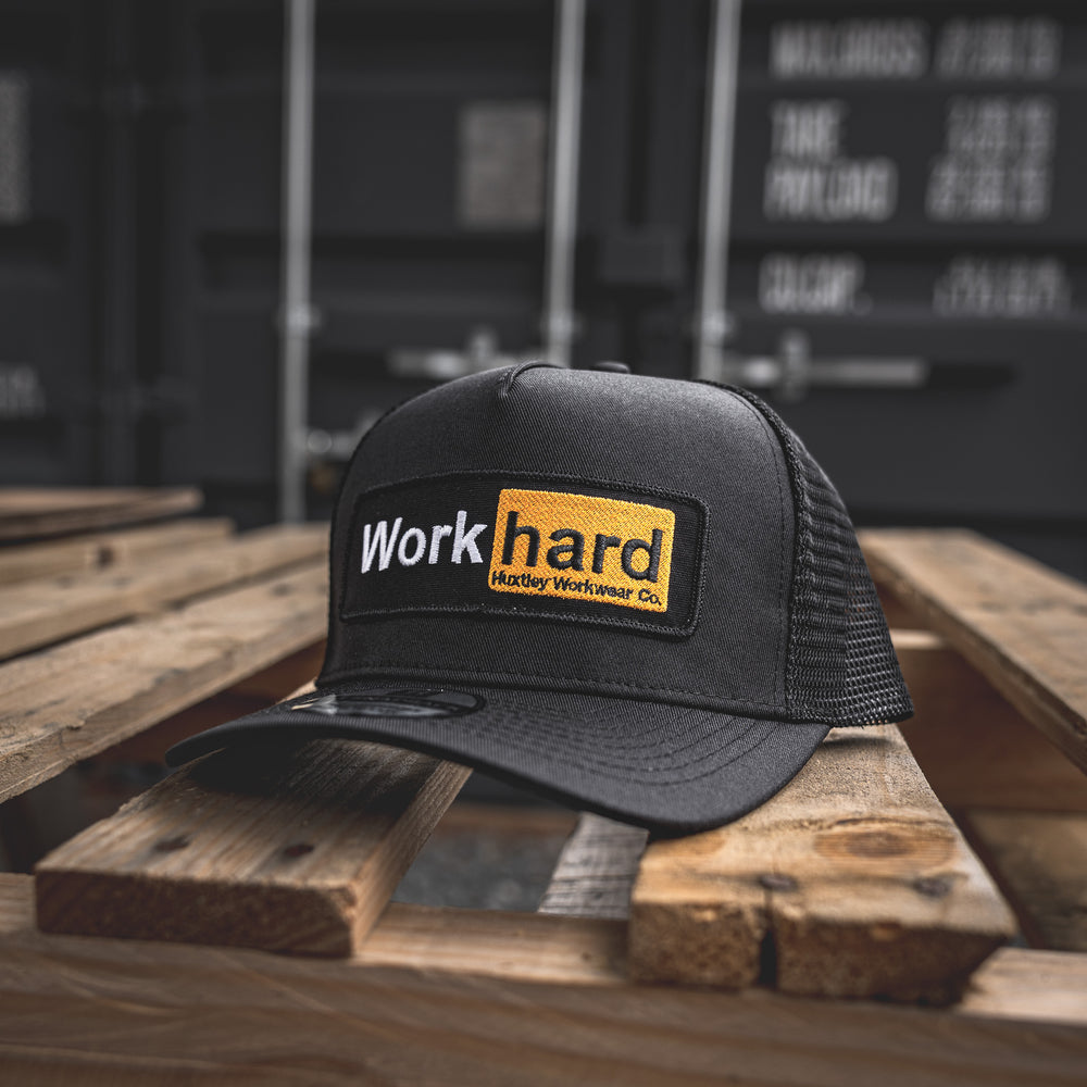 Bold yellow-on-black embroidered “Work Hard” patch on our rugged mesh trucker cap. Built for long days and no-nonsense crews.