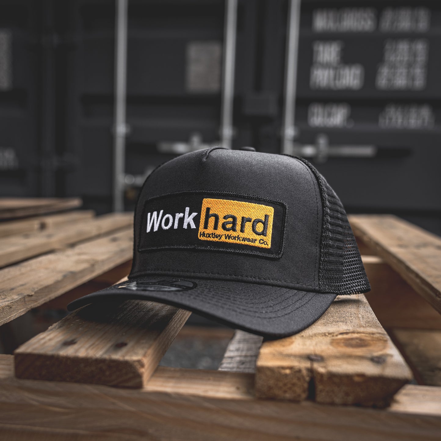Bold yellow-on-black embroidered “Work Hard” patch on our rugged mesh trucker cap. Built for long days and no-nonsense crews.