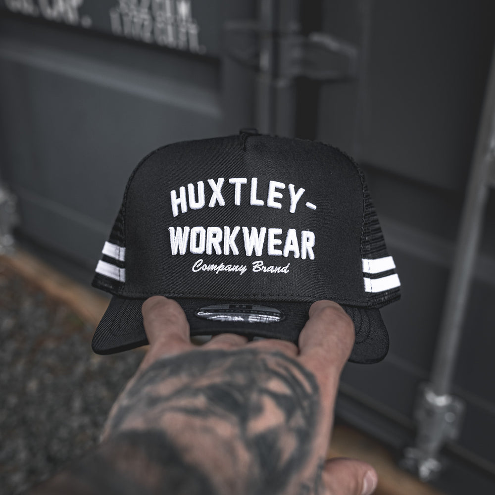 
                  
                    The Throwback Cap from Huxtley Workwear brings old-school energy with bold embroidery, mesh back, and double-stripe detail. Built for trades, styled for everyday grind.
                  
                