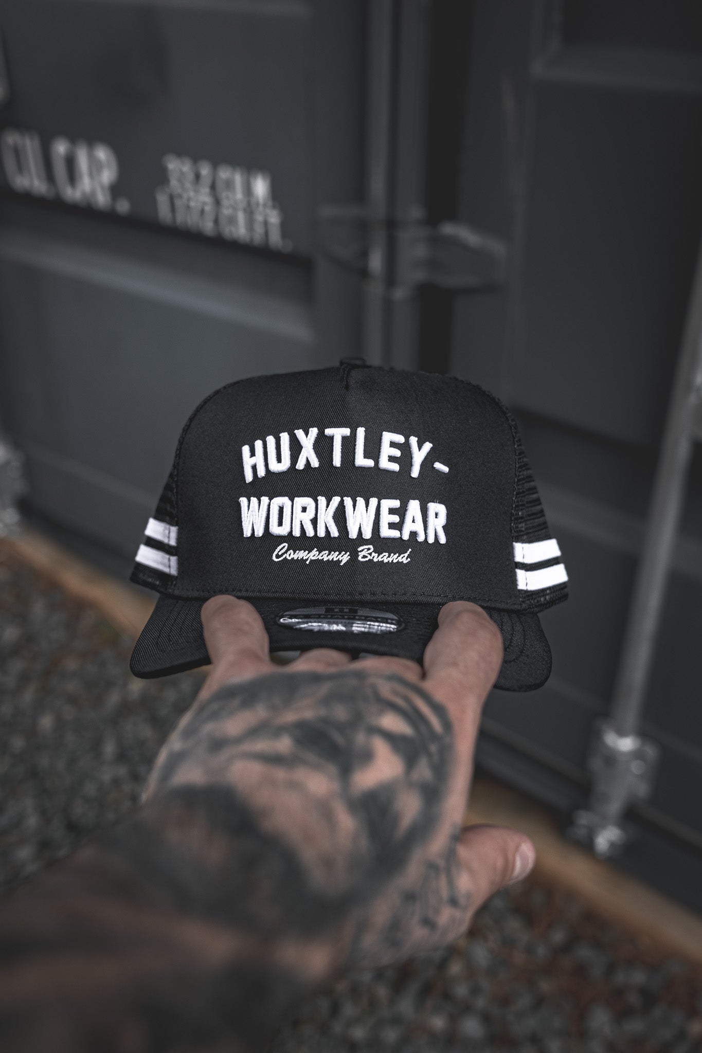 
                  
                    The Throwback Cap from Huxtley Workwear brings old-school energy with bold embroidery, mesh back, and double-stripe detail. Built for trades, styled for everyday grind.
                  
                